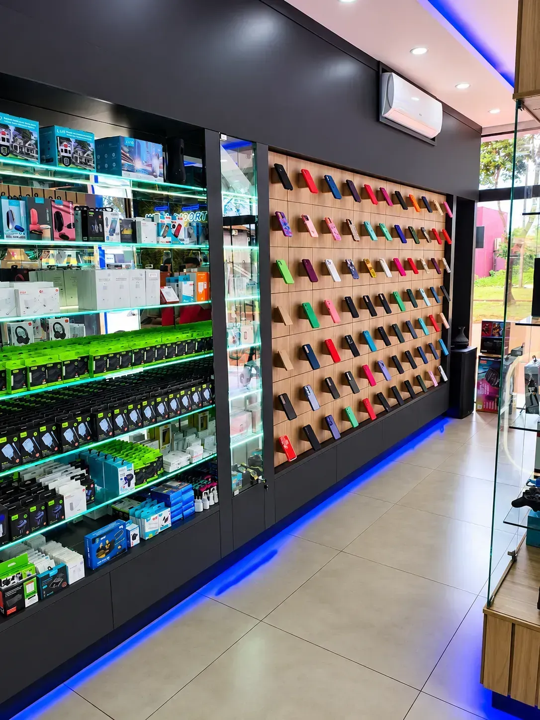 Parede de capinhas coloridas e vitrine de fones, carregadores e acessorios